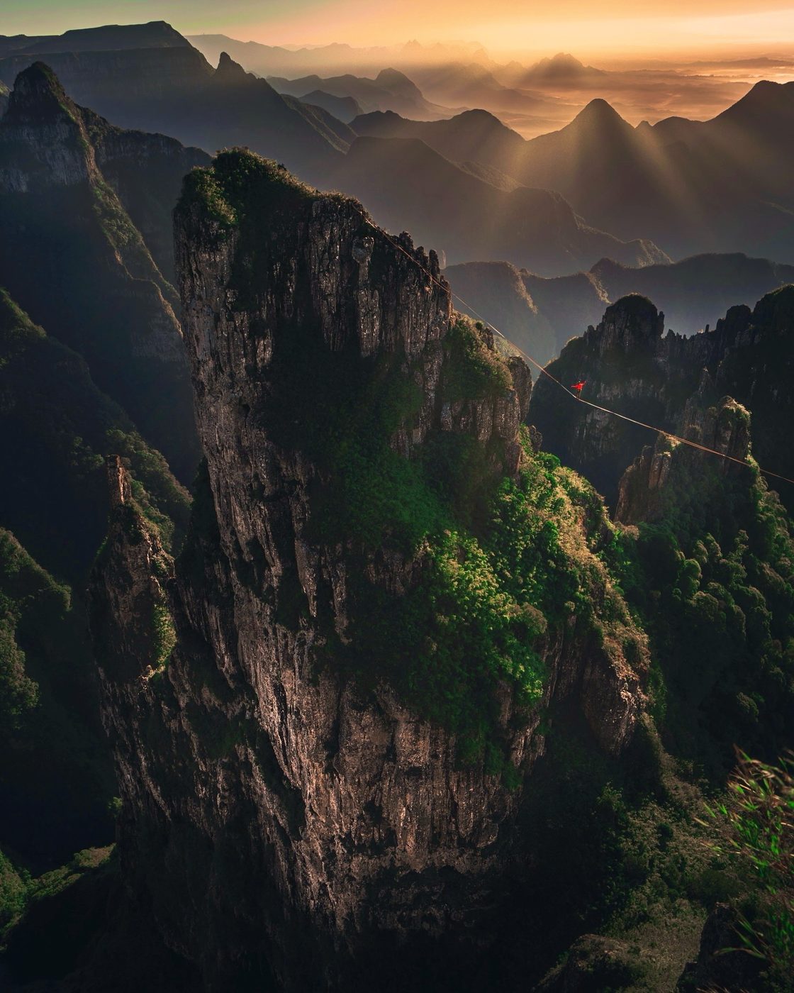 Highlining at sunset between mountain towers