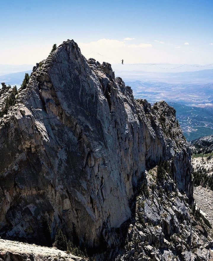 Highlining across a jagged mountain ridgeline