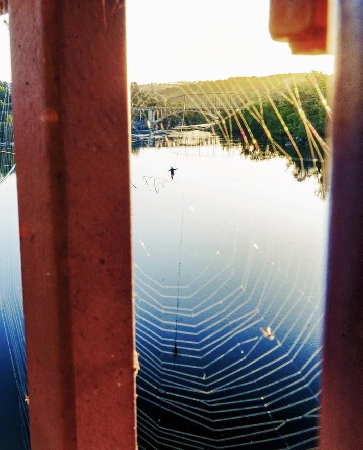 Highline mirrored over still water at dawn
