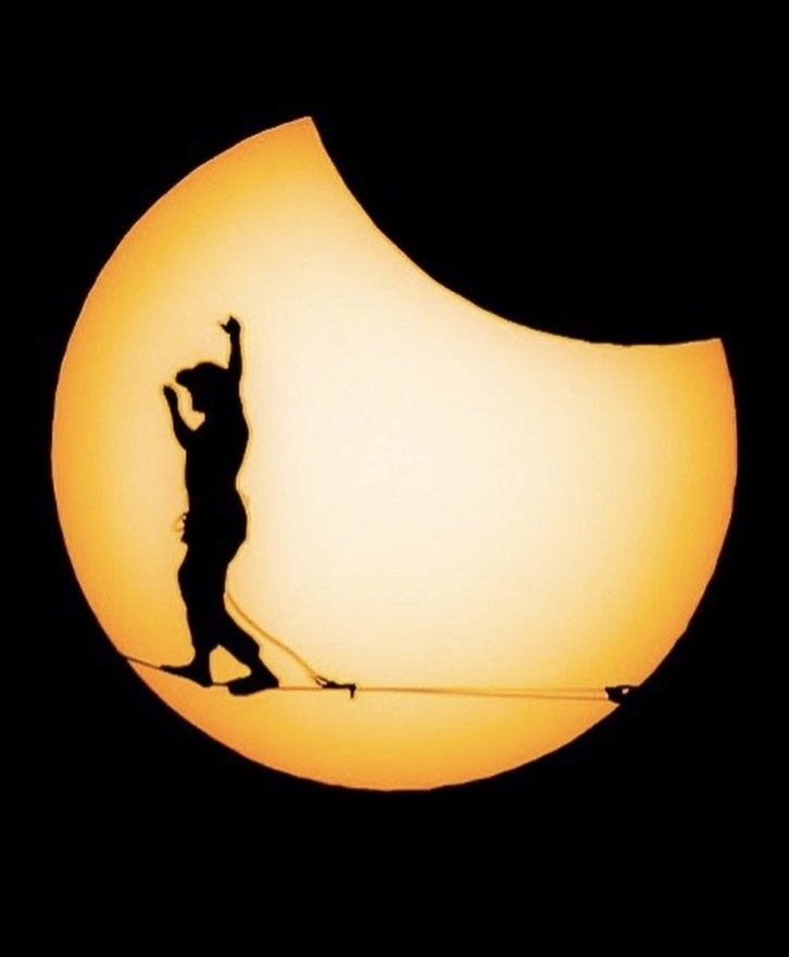 Highliner silhouetted inside a solar eclipse